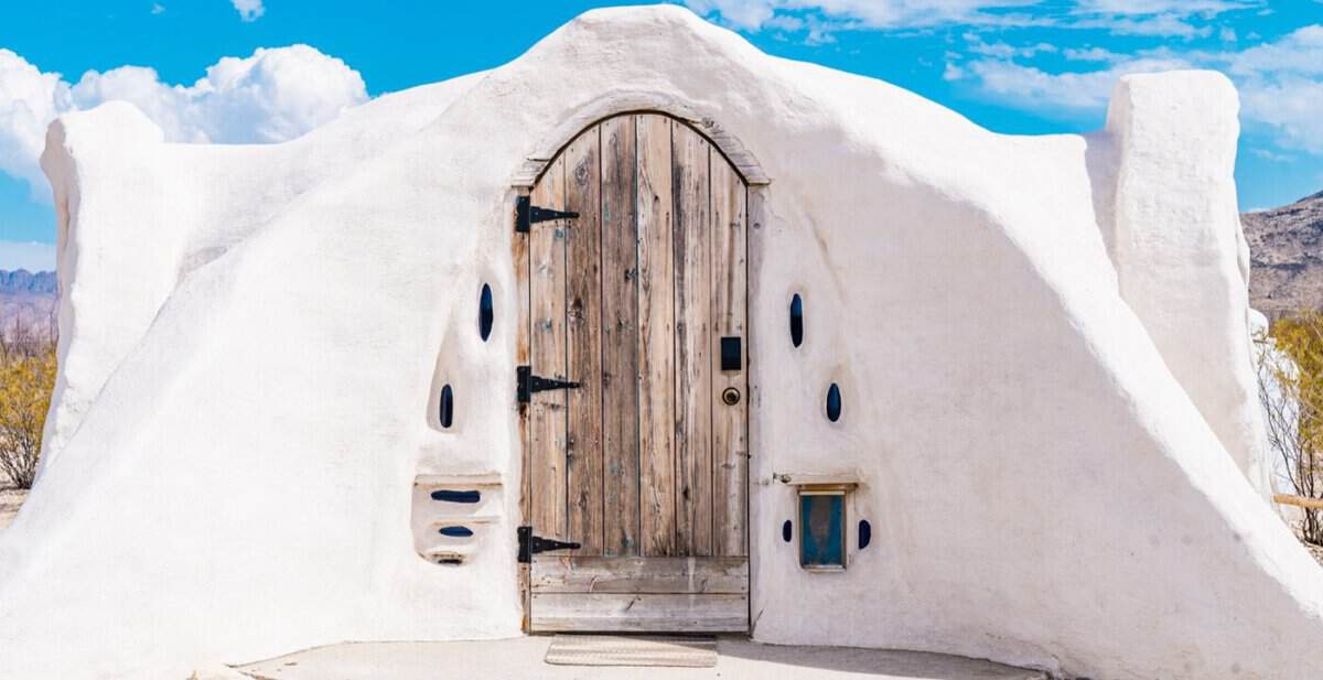 White cave-style stay exterior with a wooden door near Big Bend