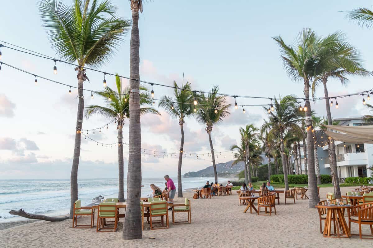 Beachfront tables and string lights at Mezquite restaurant at Conrad Punta de Mita.