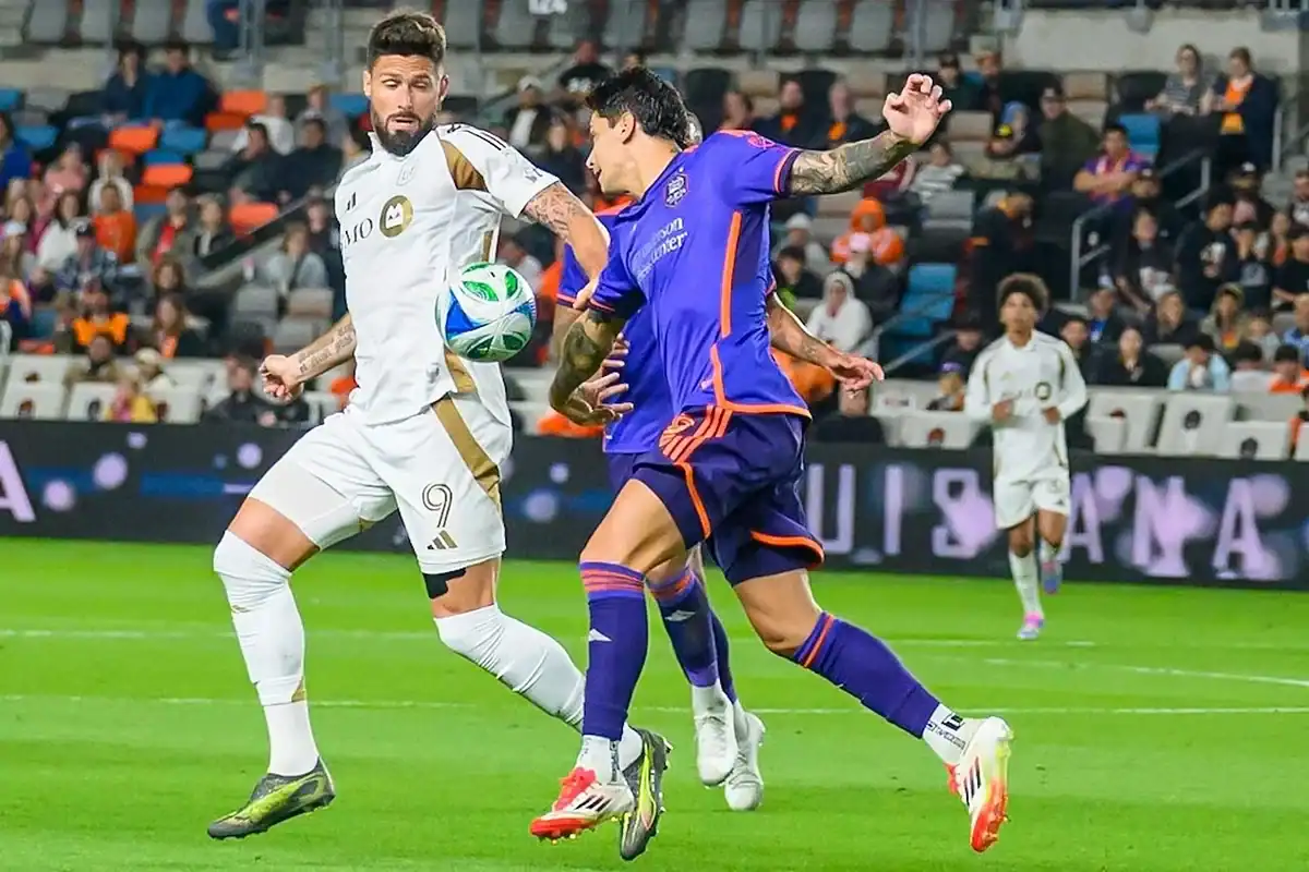 Houston Dynamo player challenging an LAFC player during a 2025 match in Houston