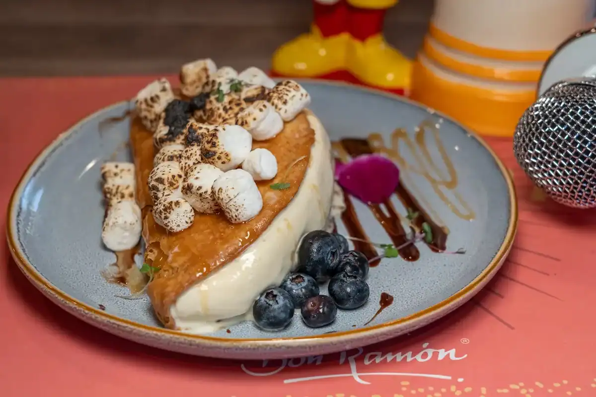 Dessert topped with toasted marshmallows and blueberries at Sin Yolanda
